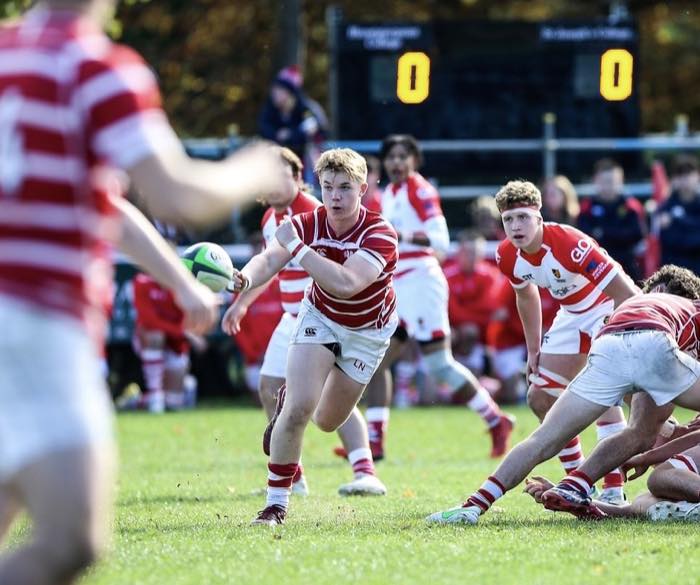 Louis playing rugby, passing the ball
