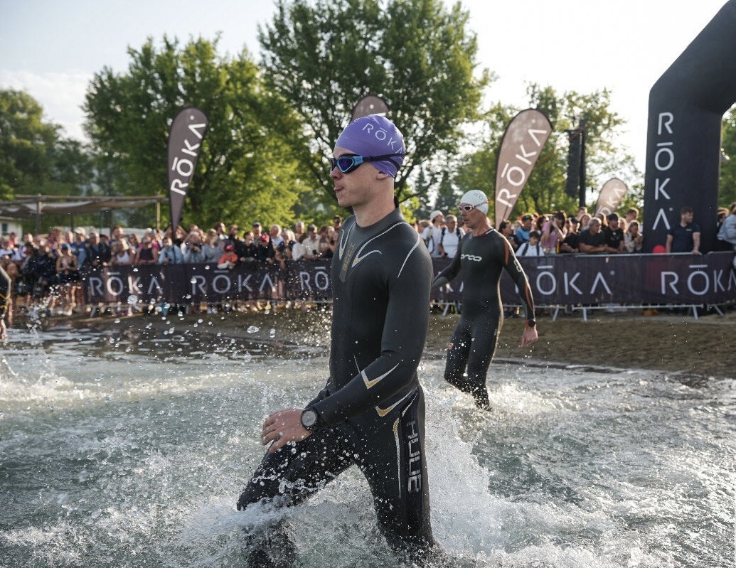 Louis in his wetsuit, about to enter the water at the start of a triathlon