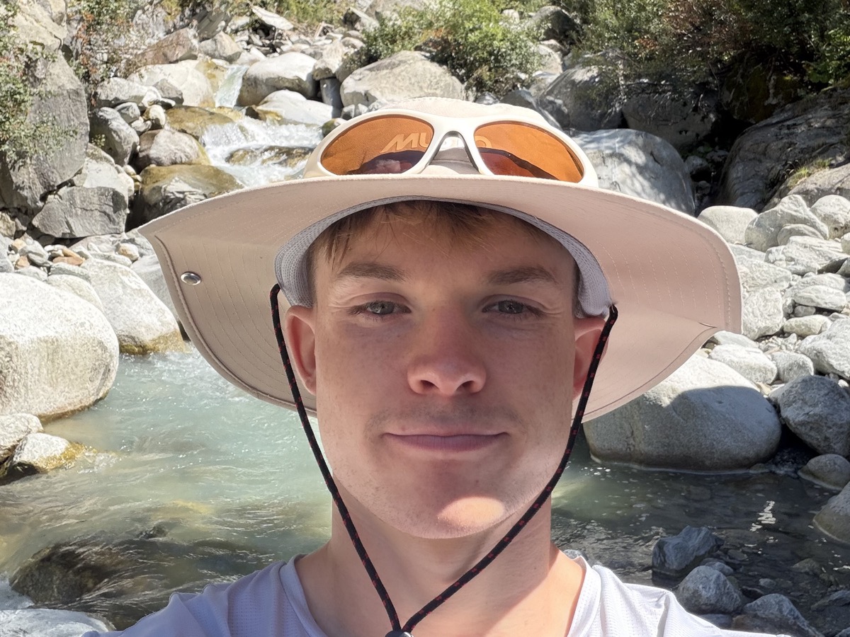 Louis in a sun hat by a mountain river
